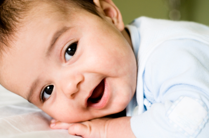 Smiling laughing baby with head on hands